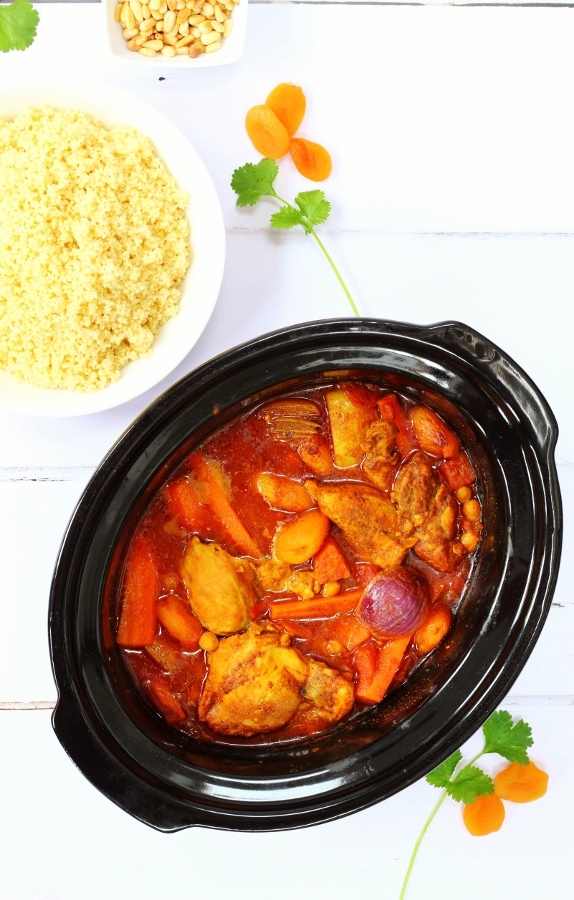 Slow cooker chicken tagine in the Crock pot with a bowl of couscous on the side