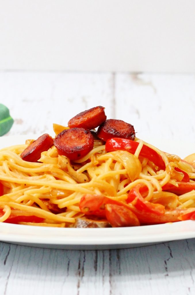 plate of spaghetti with a creamy red pepper mushroom sauce and crispy pieces of chorizo