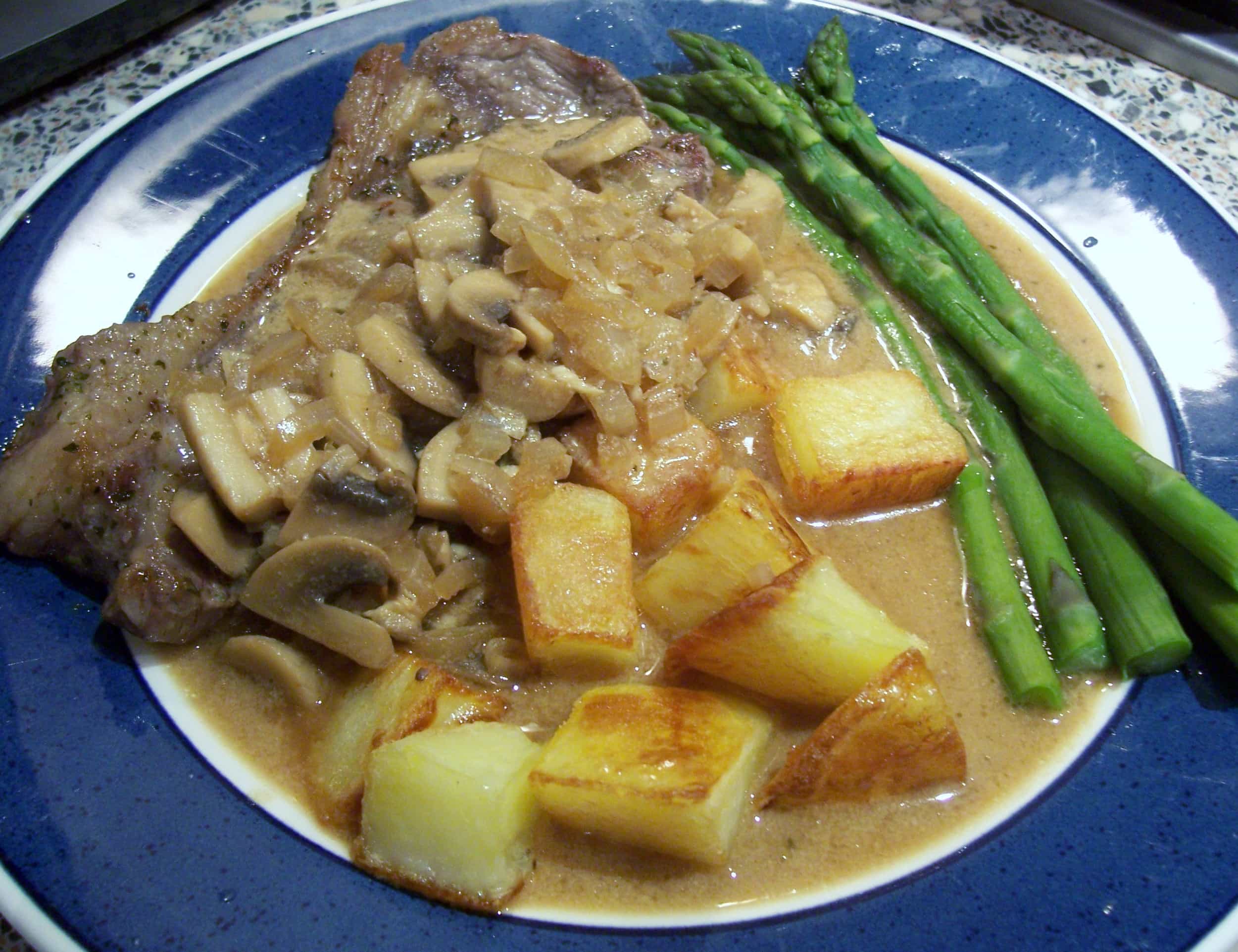 Steak with a creamy mushroom and whisky sauce with potatoes and asparagus
