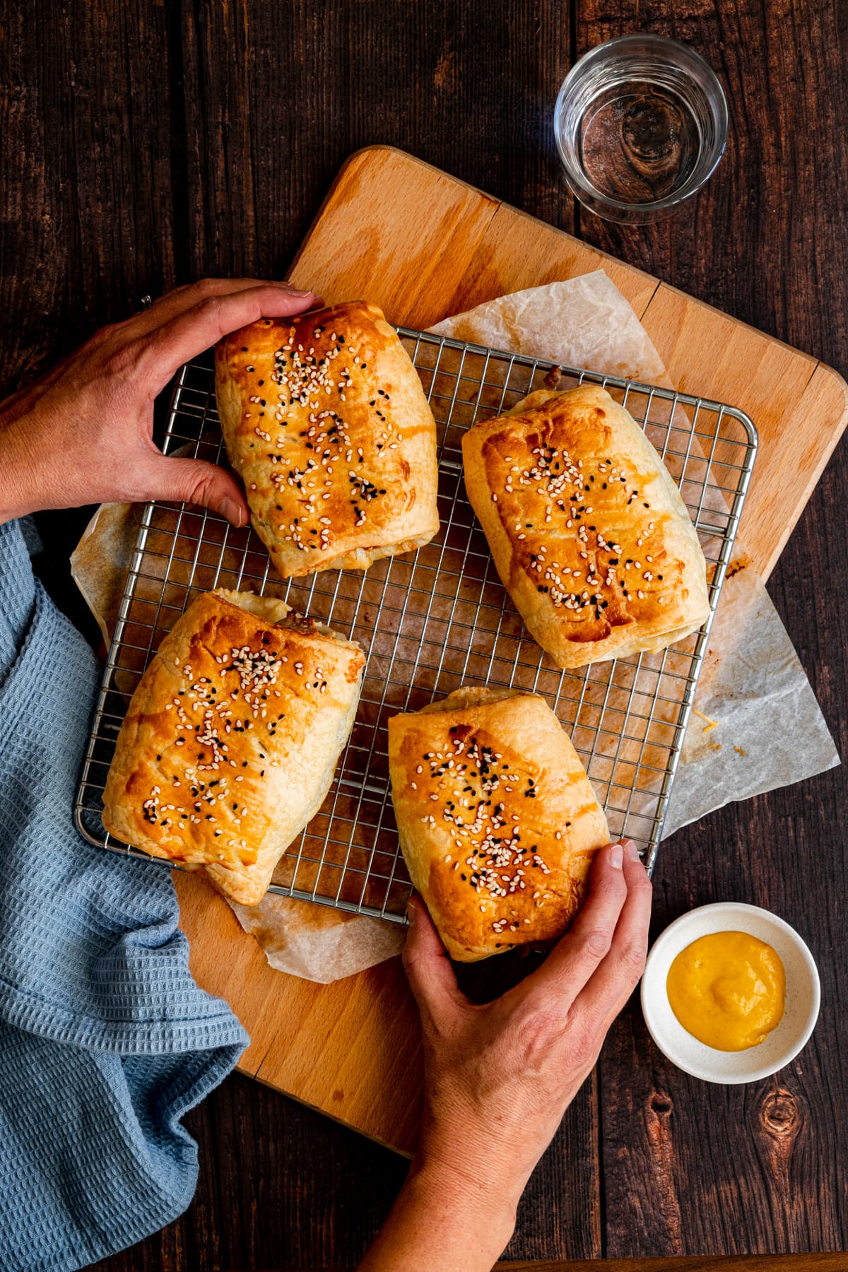 hands taking sausage rolls