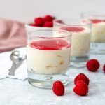 Three glasses with white chocolate mousse and raspberry sauce