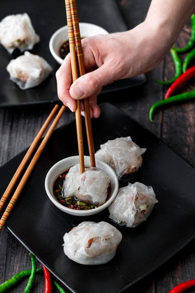 hand holding chopsticks with a dumpling