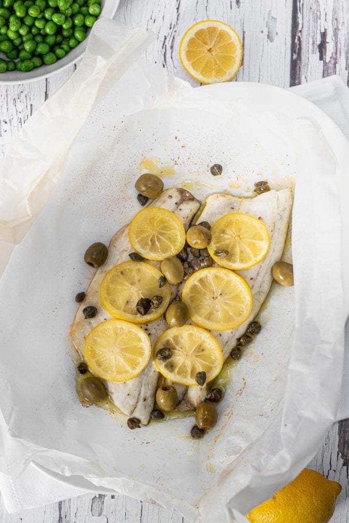 Sea bass with lemon slices, capers and olives