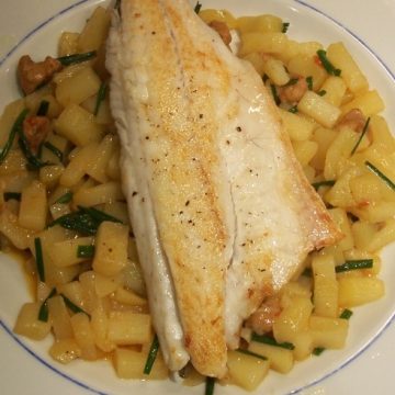 plate of chorizo and potato risotto with sea bass on top