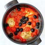 Pot of Italian chicken stew with peppers, olives and tomatoes