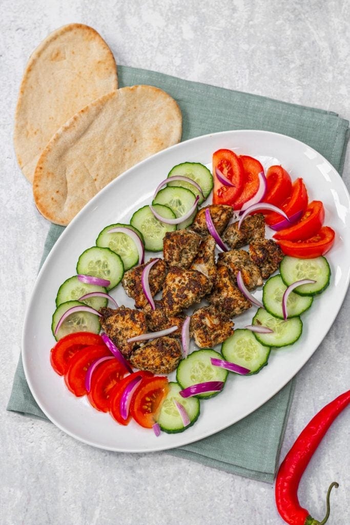 Platter of chicken cafrael with tomatoes and cucumber