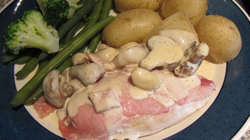 chicken topped with bacon in a creamy mushroom bacon sauce with potatoes, broccoli and green beans.