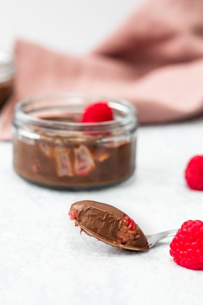 Chocolate raspberry dessert pots with a spoonful of chocolate