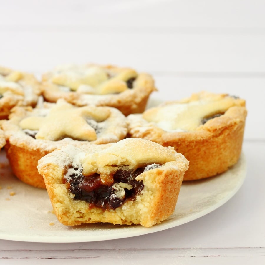 Plate of mince pies.  One mince pie has a bite taken out.