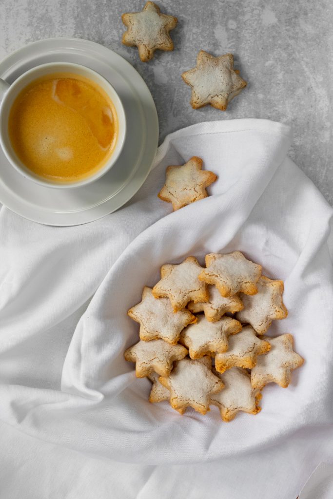 flatlay of cinnamon star biscuits with cup of coffee