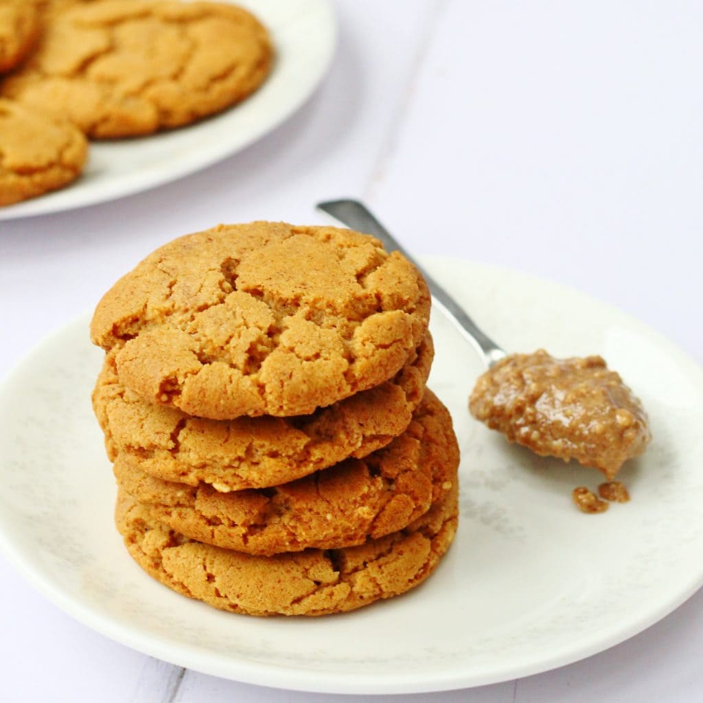 Stack of peanut butter cookies and spoonful of peanut butter