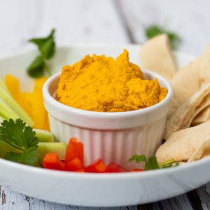 Roasted Carrot Dip in a ramekin with veggie sticks