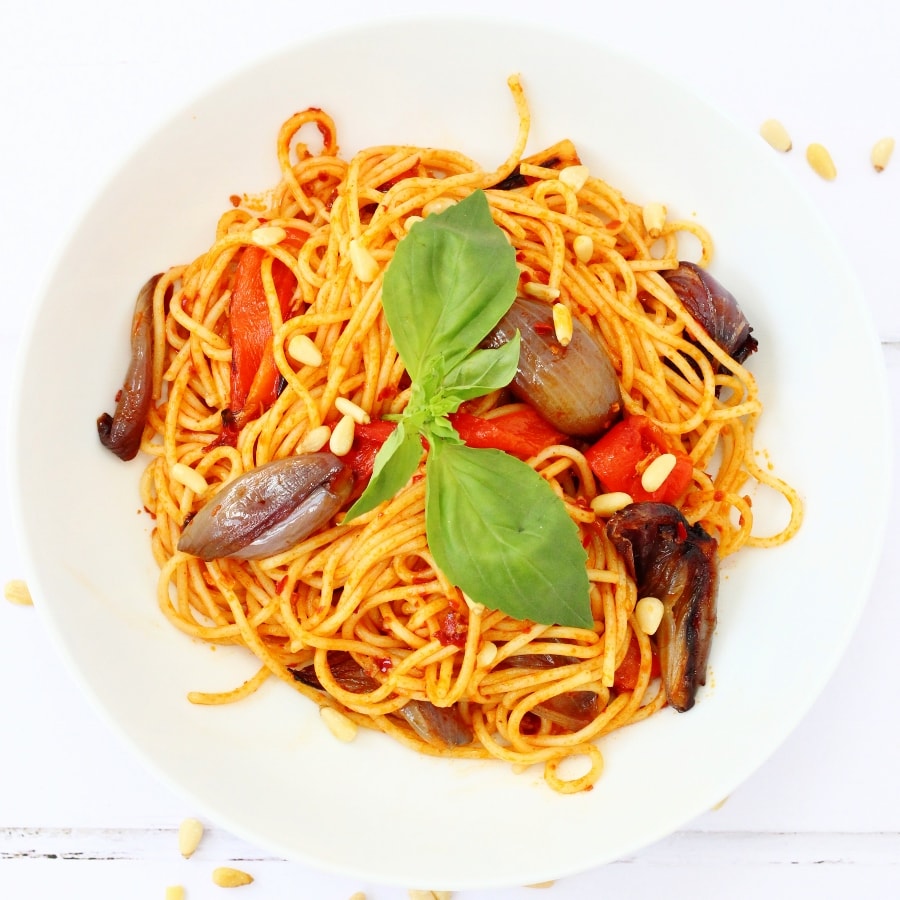 bowl of harissa pasta with roasted vegetables and pine nuts