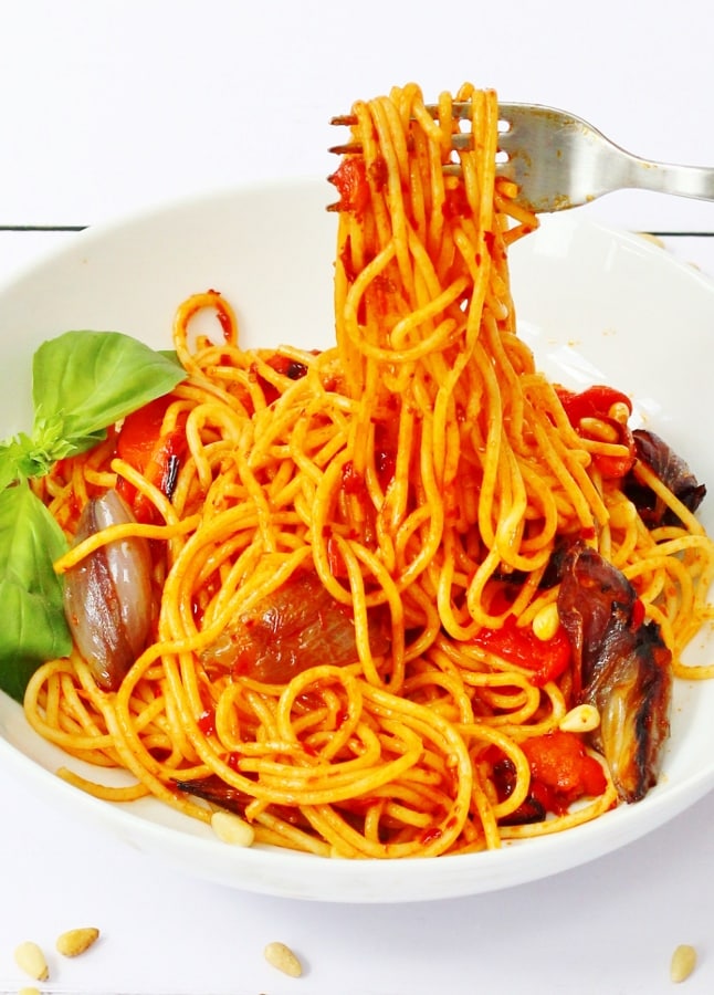 Harissa spaghetti on a fork with roasted vegetables