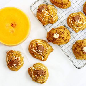 Spiced pumpkin cookies decorated with chocolate webs and spiders for Halloween