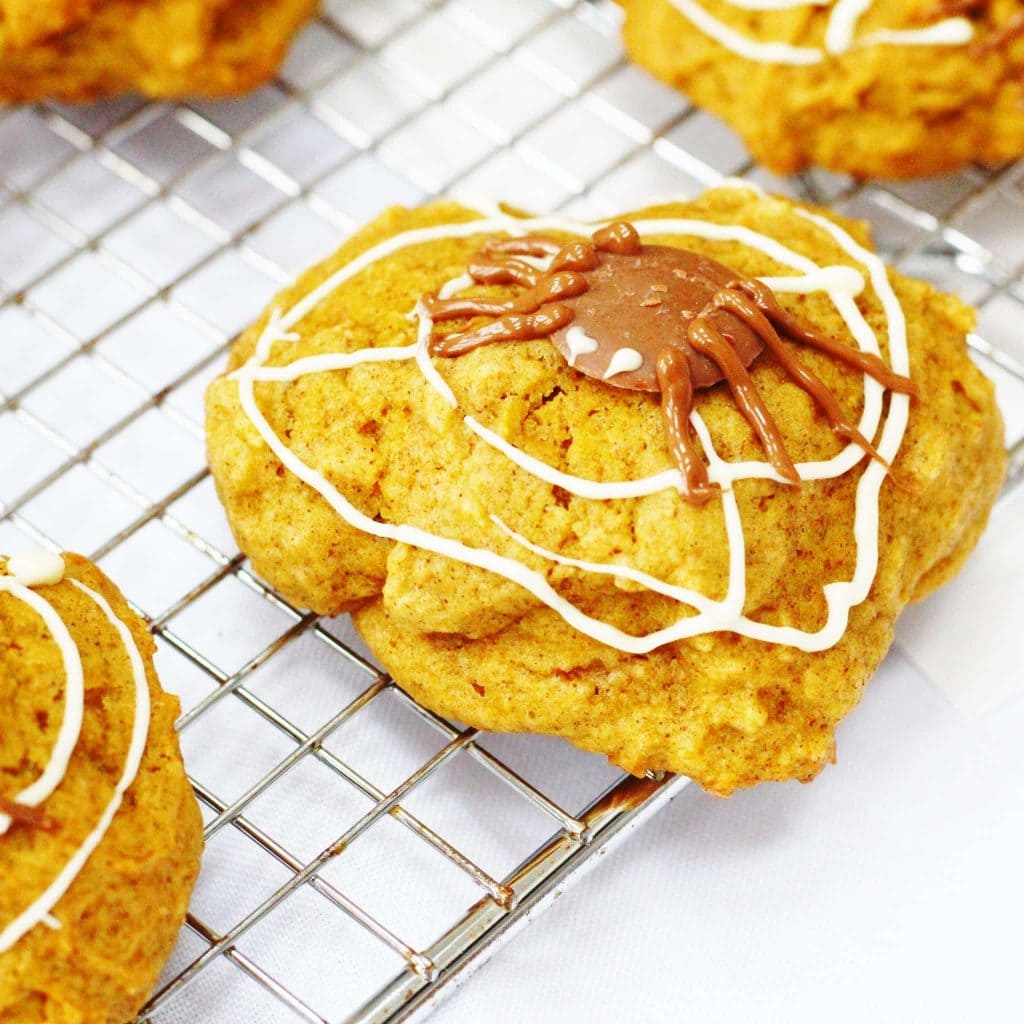 Spiced pumpkin cookies decorated with chocolate webs and spiders for Halloween