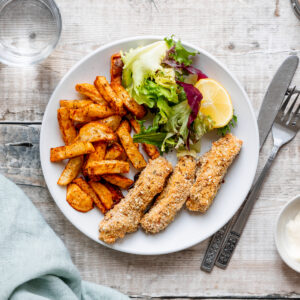 Plate of cod and dukkah fish fingers with chips and salad