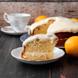 slice of orange buttermilk cake with cake in the background