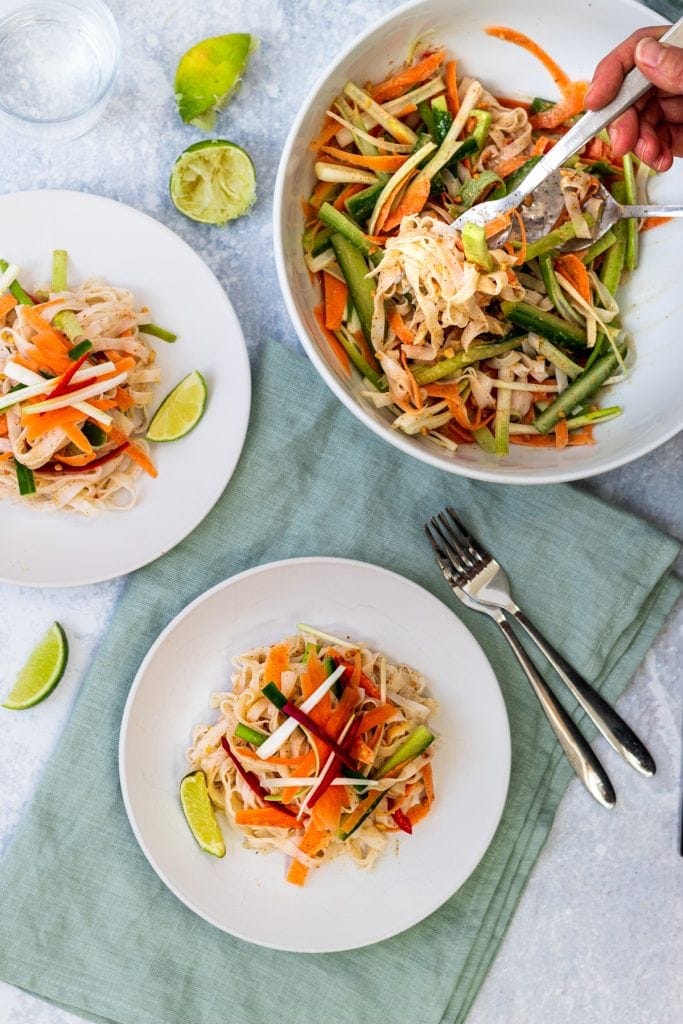 Peanut butter noodle salad in a bowl and on plates