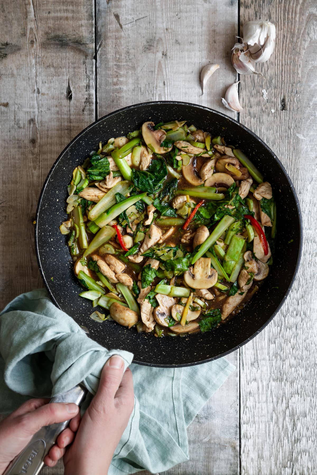 Cauliflower leaf chicken stir fry in a wok