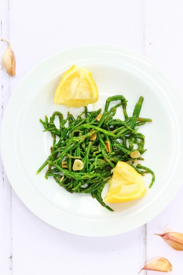 Bowl of garlicy samphire with lemons