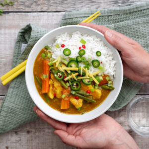 hands holding Chinese chicken curry bowl