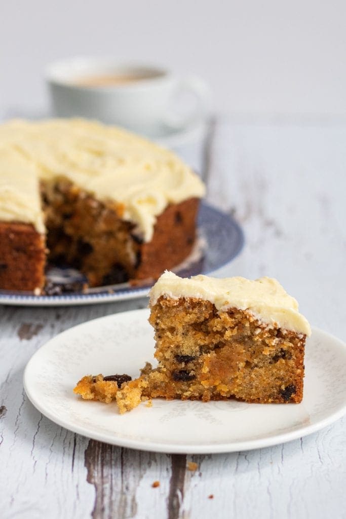 vegan carrot cake slice with cake in background