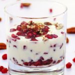 Pin image for pomegranate yogurt fool showing side of a glass with yogurt, pomegranate and pecan nuts