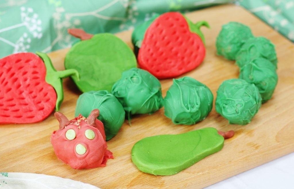 hungry caterpillar cake balls coated in red and green candy melts