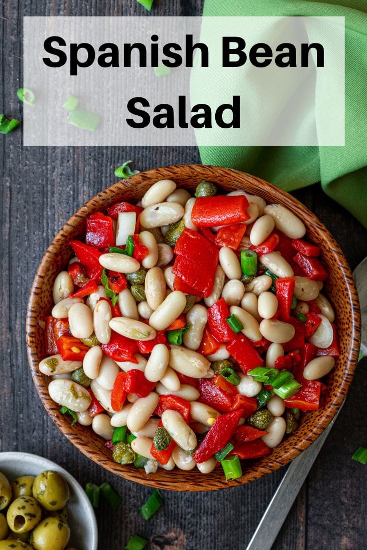 Bowl of Spanish bean salad with text overlay