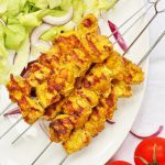 Spanish chicken kebabs with lettuce, tomatoes and red onions