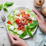 BLT salad with hands holding plate