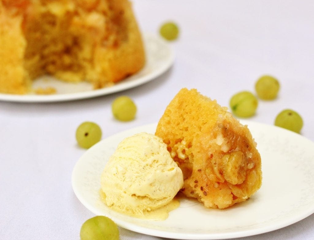 Plate of slow cooker gooseberry steamed sponge pudding with ice cream