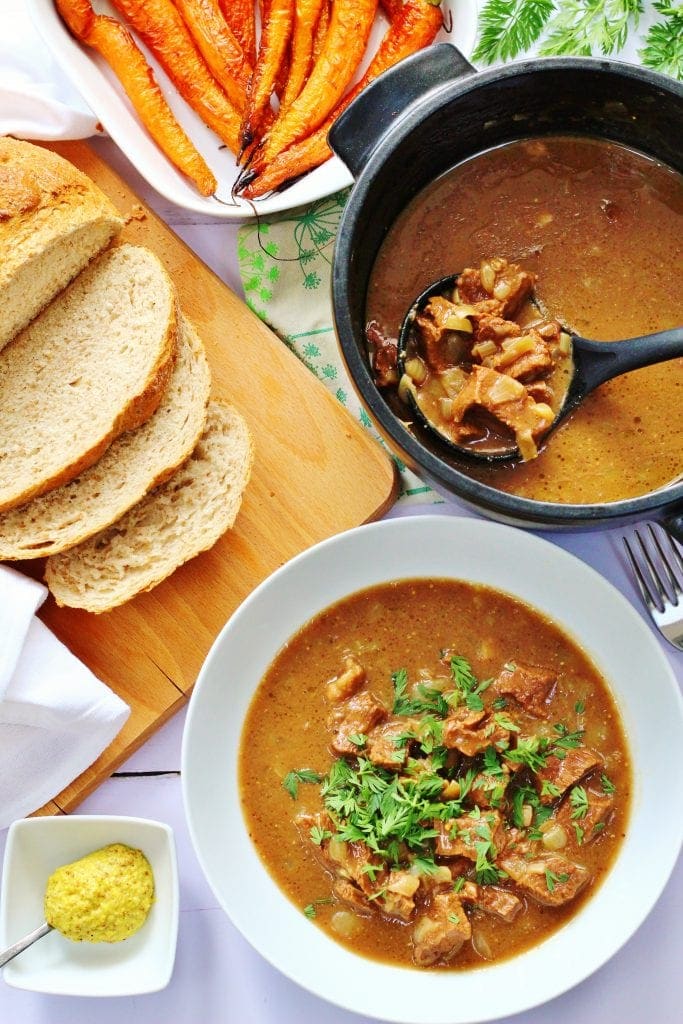 Beef stew with mustard and bread on the side