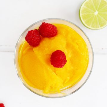 Mango sorbet in a bowl with raspberries