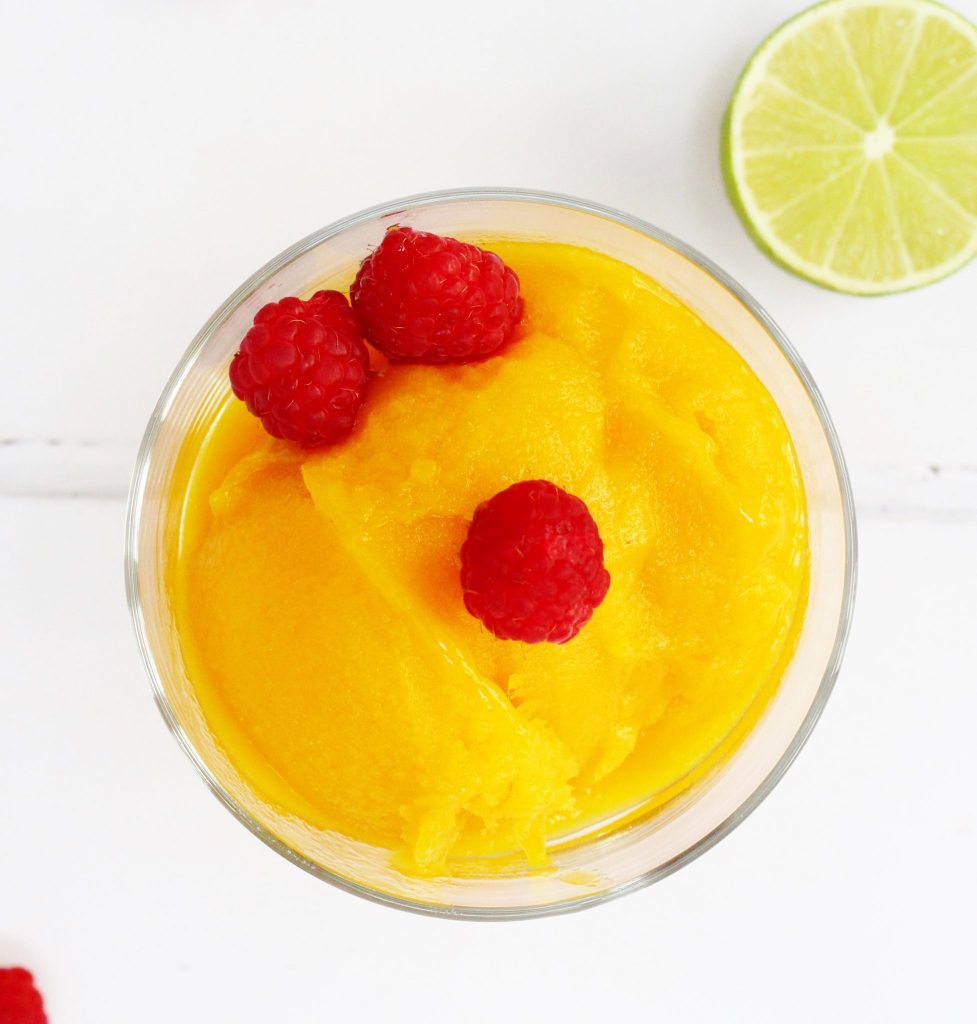 Mango sorbet in a bowl with raspberrys