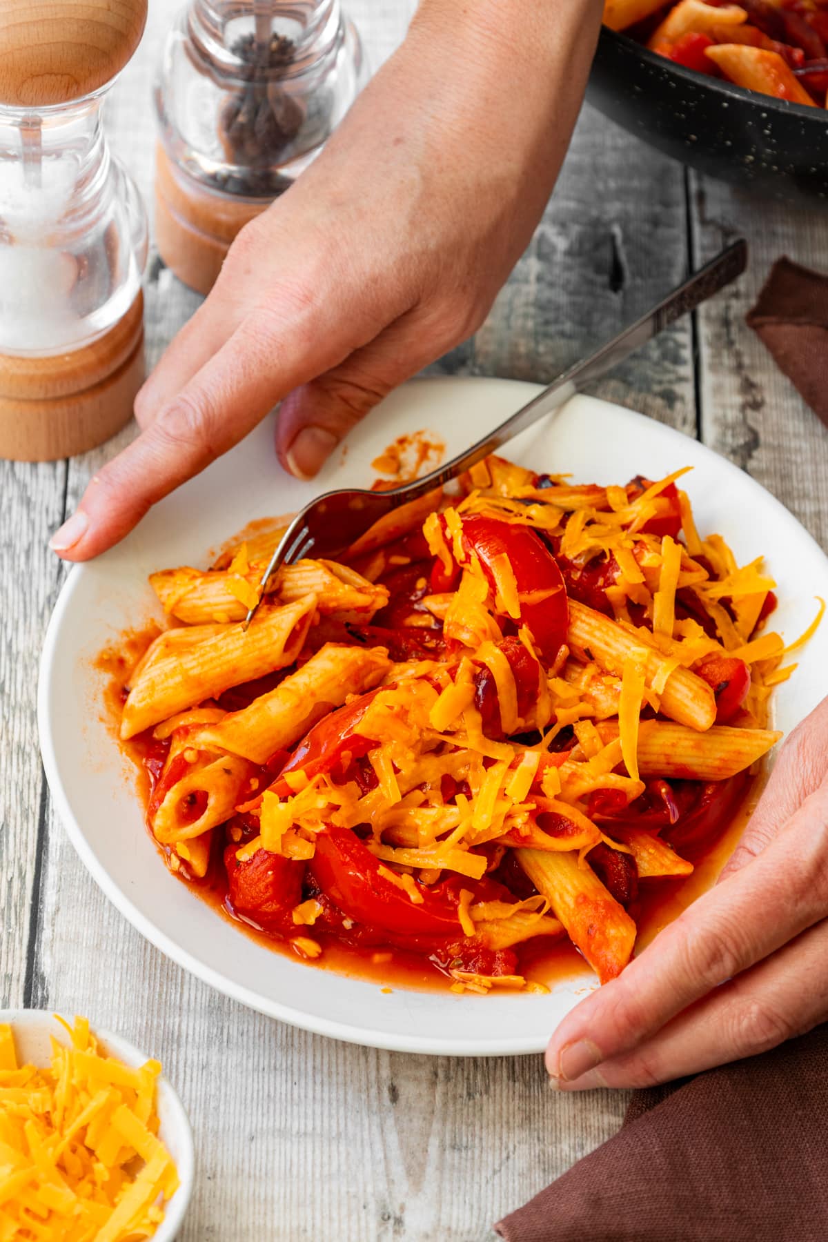 A bowl of tomato pasta topped with Red Leicester cheese