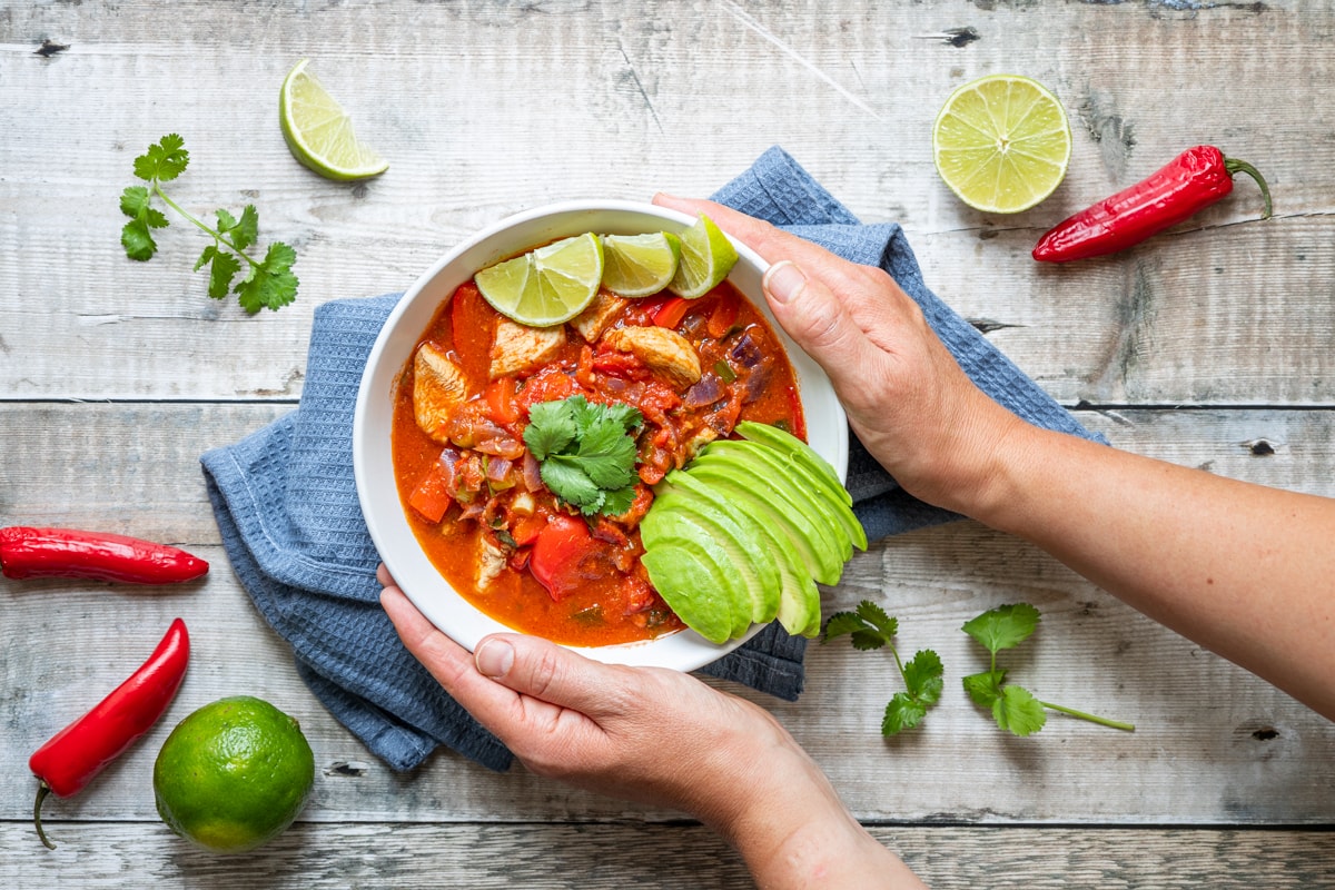 Hands holding Mexican chicken stew