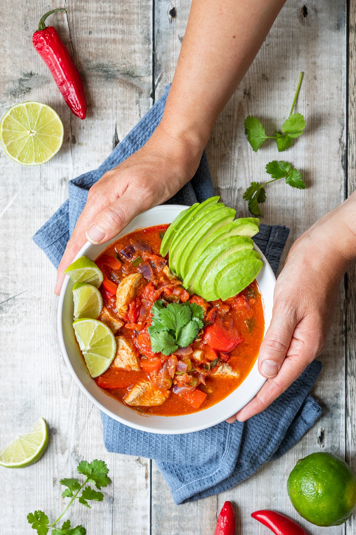 Bowl of Mexican Chicken Stew with hands holding it