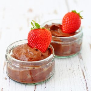 Two ramekins of cauliflower chocolate mousse topped with a strawberry