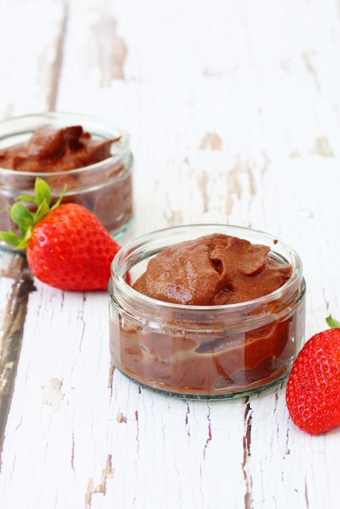 Two ramekins of cauliflower chocolate pudding with a strawberry