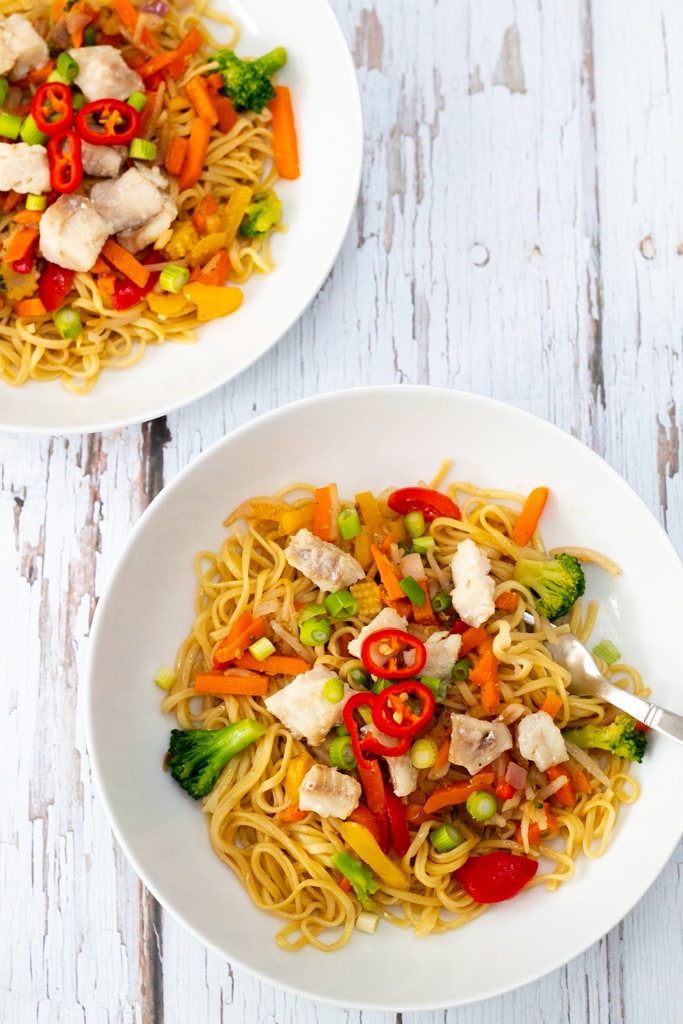 two bowls of stir fry noodles with Alaskan pollock