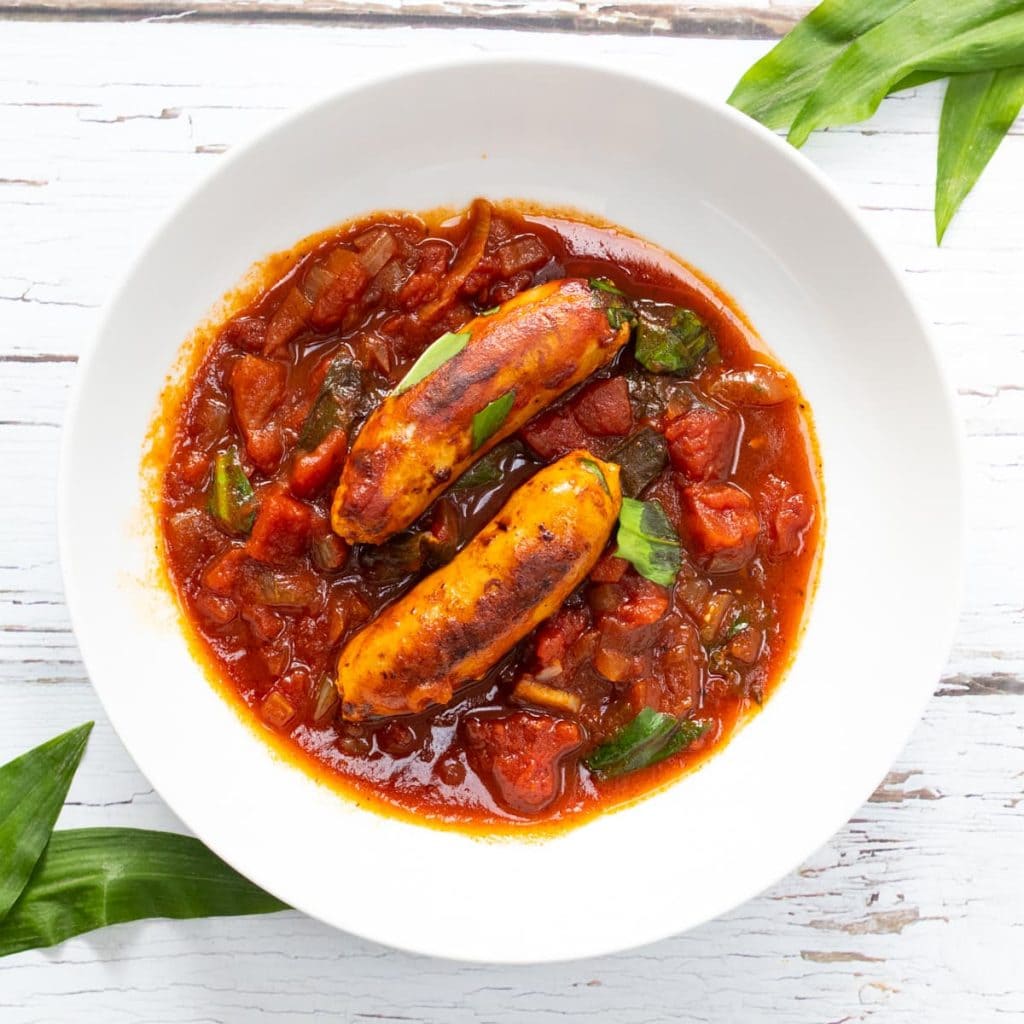 Sausage wild garlic stew in a white bowl