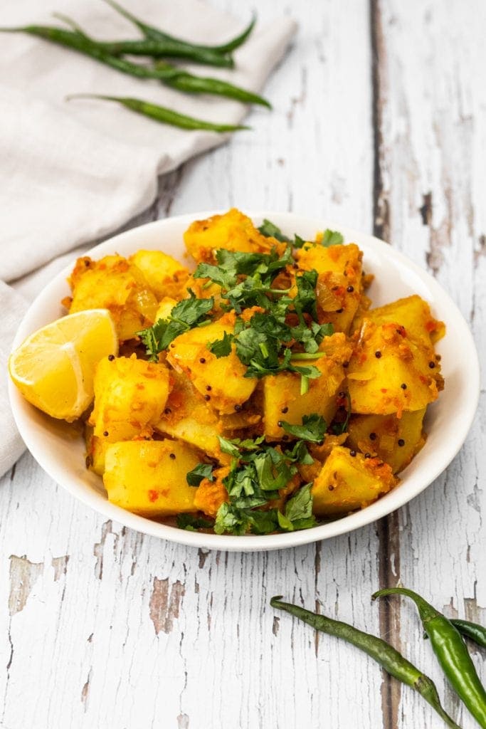 Bowl of Bombay potatoes topped with coriander
