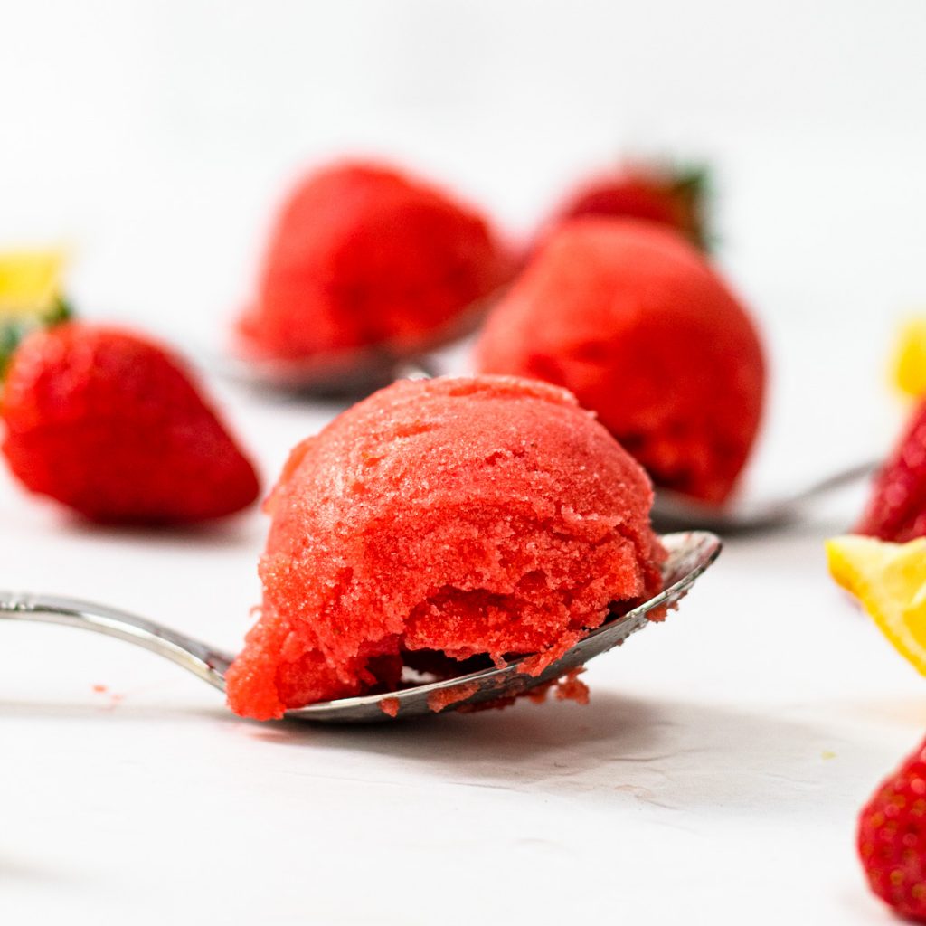 Scoop of strawberry sorbet on a spoon