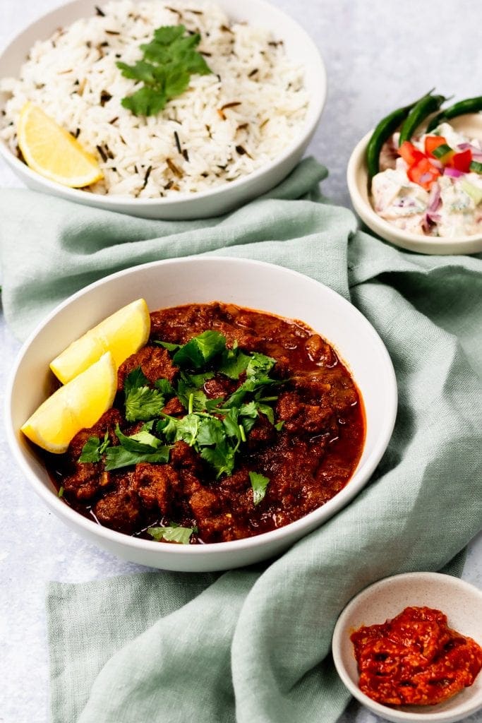 bowl of lamb vindaloo with rice and chutney