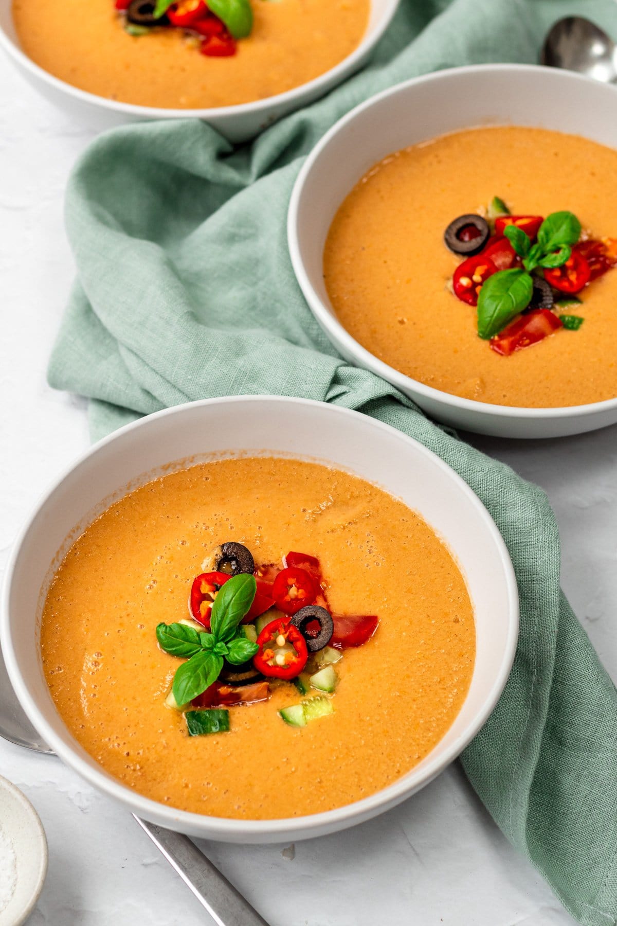 Three bowls of spicy gazpacho