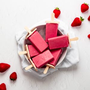 Bowl of strawberry coconut milk ice lollies