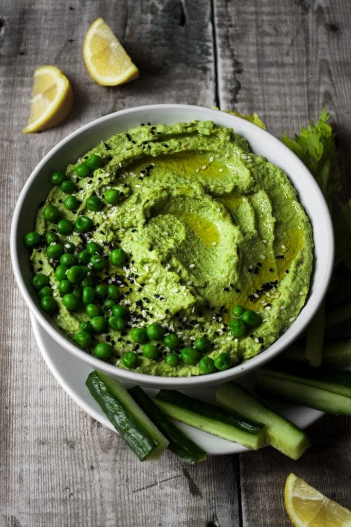 bowl of pea hummus with vegetable sticks