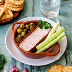 Bowl of feta dip with olives and celery sticks